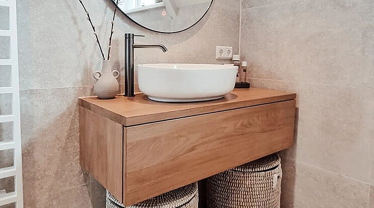 Beige badkamer met houten badkamermeubel en gunmetal kraan